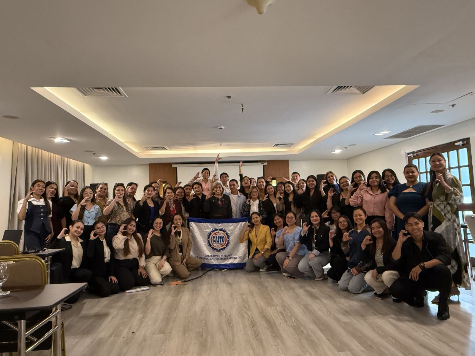 Seminar participants gathered around the CAITO flag at the Filipino Brand of Service Excellence session